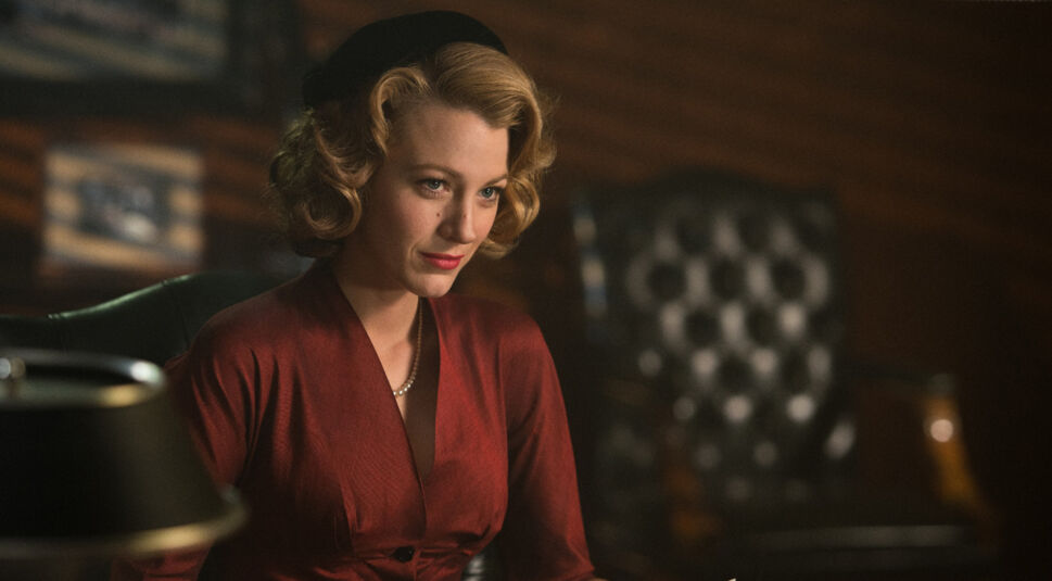 Im featured-Artikel zu den besten Filmen und Serien mit Blake Lively ist ein Bild von Blake Lively in ihrer Rolle als Adaline Bowman in dem Film Für immer Adaline. Das Bild zeigt sie von schräg vorne leicht im Profil im Brustporträt. Sie sitzt in einem dunklen Raum. Ihre Frisur und ihr Outfit lassen darauf schließen, dass die Szene in den 1950ern oder 60ern spielt. Sie trägt eine samtrote Bluse und eine weiße Perlenkette. Ihre Haare enden über der Schulter und sind in Wellen nach oben geföhnt. Sie trägt außerdem leicht roten Lippenstift.