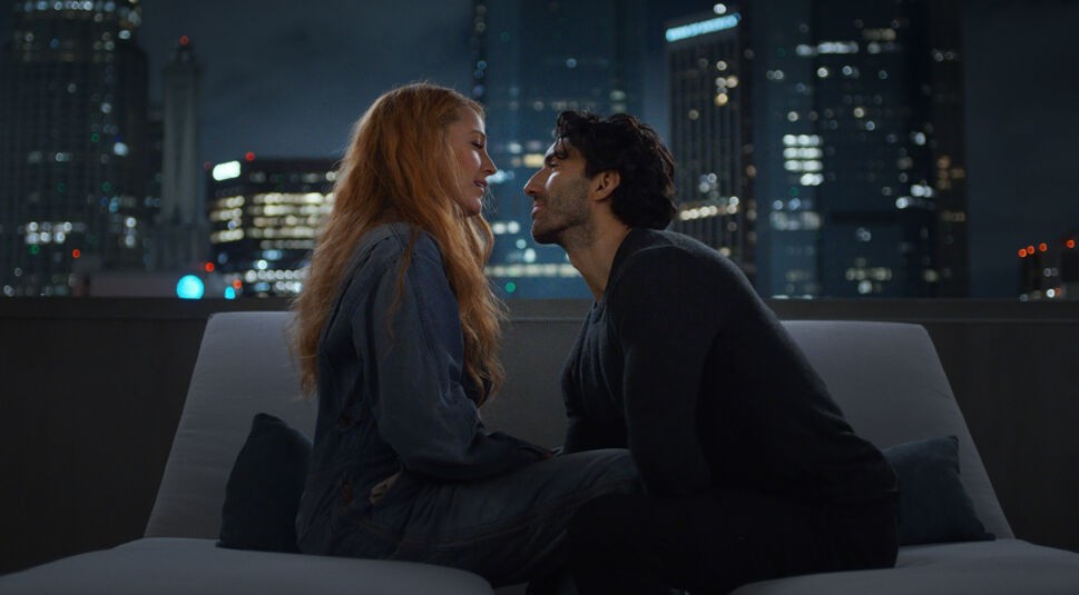 DIe Figuren Lily und Ryle aus dem Film Nur noch ein einziges Mal sitzen sich im Schneidersitz auf einer grauen Couch gegenüber. Links im Bild sitzt Blake Lively als Lily, rechts im Bild sitzt Justin Baldoni als Ryle. Es scheint relativ dunkel im Raum zu sein. Die beiden sitzen vor einem Fenster oder draußen. Im Hintergrund sind einige Hochhäuser zu sehen, in denen einige Räume erleuchtet sind. Es ist Nacht.
