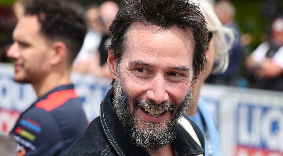 Das Bild in dem Artikel 10 Keanu Reeves-Fakten zeigt den Schauspieler im Porträt. Er hat einen grau-schwarzen Vollbart und seine kurzen Haare sind schwarz.