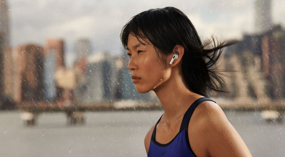 Frau macht mit AirPods 3 im Ohr Sport im Regen