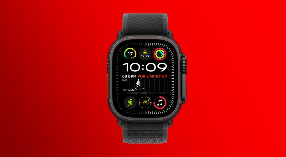 Auf diesem Bild zum Apple Event 2024 ist die Apple Watch Ultra 2 in Titanium Schwarz zu sehen. Die Smartwatch zeigt ein farbenfrohes Zifferblatt mit Fitness- und Gesundheitsdaten, darunter Herzfrequenz, Aktivitätsringe und Wetter. Das robuste, schwarze Design mit einem breiten Armband unterstreicht die sportliche Funktionalität der Uhr. Der leuchtend rote Hintergrund verstärkt den Kontrast und hebt die Uhr hervor.