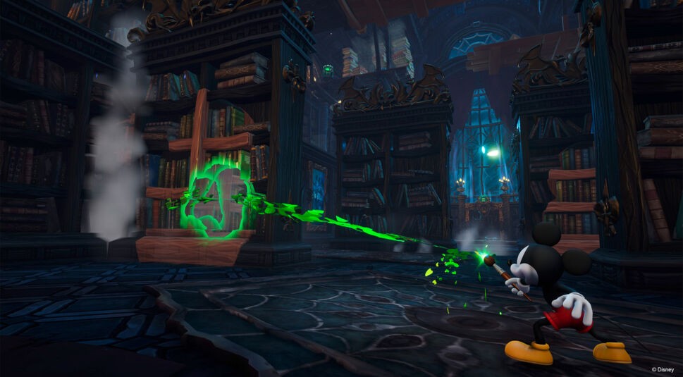 Auf dem Bild aus dem Spiel Disney Epic Mickey: Rebrushed steht Mickey Mouse in einer düsteren Bibliothek und benutzt seinen magischen Pinsel, um einen grünen Energiefluss auf ein geheimnisvolles, leuchtendes Symbol zu richten. Die Bibliothek ist mit alten, verzierten Bücherregalen gefüllt, und im Hintergrund ist ein großes gotisches Fenster zu sehen. Die Szene wirkt geheimnisvoll und spannend.