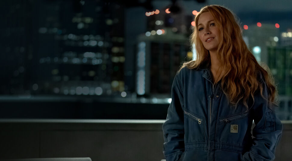 Auf dem Bild zu den GigaTV Highlights im Oktober ist Blake Lively als Lily Bloom in einer nächtlichen Szene aus "Nur noch ein einziges Mal" zu sehen. Sie steht auf einer Dachterrasse vor der Kulisse einer beleuchteten Stadt und trägt eine blaue, locker sitzende Jacke. Ihr langes, welliges Haar fällt über ihre Schultern, und sie wirkt nachdenklich und entspannt. Die ruhige Atmosphäre und die verschwommenen Lichter der Stadt im Hintergrund verleihen der Szene eine melancholische und zugleich hoffnungsvolle Stimmung.