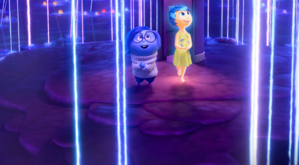 Auf dem Bild zu den GigaTV Highlights im Oktober sind die Charaktere Freude und Kummer aus "Alles steht Kopf 2" zu sehen. Freude leuchtet in ihrem gelben Kleid und trägt eine strahlende Kugel, während Kummer in ihrem blauen, melancholischen Look neben ihr läuft. Sie befinden sich in einer futuristischen, bunten Landschaft mit leuchtenden Linien und einer traumhaften Atmosphäre. Die Szene vermittelt eine Mischung aus Staunen und emotionaler Tiefe, passend zur Stimmung des Films.