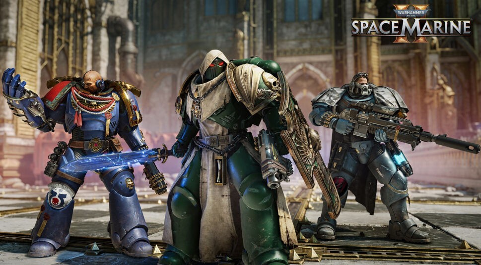 Auf dem Bild zu Warhammer 40.000: Space Marines 2 sind drei Space Marines in voller Rüstung zu sehen. Links steht ein Marine in blauer Rüstung mit einem leuchtenden Energieschwert, in der Mitte ein in grün und beige gehüllter Space Marine mit Kapuze und einem großen Schild, rechts ein Marine mit futuristischer Scharfschützenwaffe. Die imposanten Krieger stehen vor einer zerstörten, gotischen Struktur und strahlen Entschlossenheit aus. Das Bild vermittelt die düstere und epische Stimmung des Spiels.