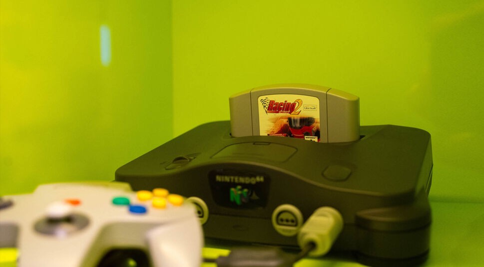 Die Nintendo 64 mitsamt des Controllers in einem grünen Schrank