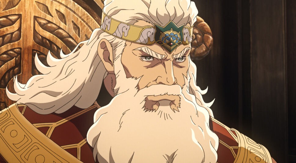 Auf diesem Bild aus Der Herr der Ringe - Die Schlacht der Rohirrim ist Helm Hammerhand zu sehen. Er trägt eine goldene Krone mit filigranen Verzierungen und einem Edelstein, die seine königliche Herkunft betont. Sein markantes Gesicht mit dem langen, weißen Bart und den entschlossenen Augen verleiht ihm eine beeindruckende und weise Ausstrahlung. Der Hintergrund aus dunklem Holz unterstreicht die majestätische und ernste Atmosphäre der Szene.