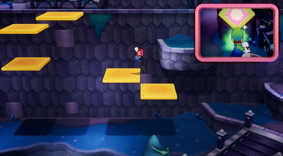 Auf dem Bild aus Mario & Luigi: Brothership Test springt Mario über gelbe Plattformen an einer dunklen Steinwand entlang, scheinbar in einer unterirdischen Höhle. In der oberen rechten Ecke ist ein kleiner Bildausschnitt, der zeigt, wie Luigi vor einem leuchtenden, rautenförmigen Symbol steht, das grün schimmert. Die Szene wirkt abenteuerlich und hebt das Erkundungselement des Spiels hervor.