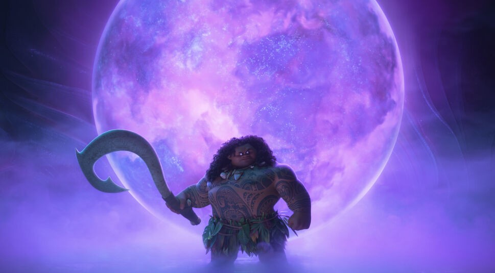 Auf dem Bild in dem Artikel über den möglichen Film "Vaiana 3" ist der Charakter Maui zu sehen, dargestellt mit kräftiger Statur, langen lockigen Haaren und seinen Tattoos. Er trägt ein Blättergewand und hält seinen magischen Haken in der Hand. Im Hintergrund leuchtet eine große, lilafarbene, kugelförmige Lichtquelle mit einem schimmernden, nebelartigen Umfeld.