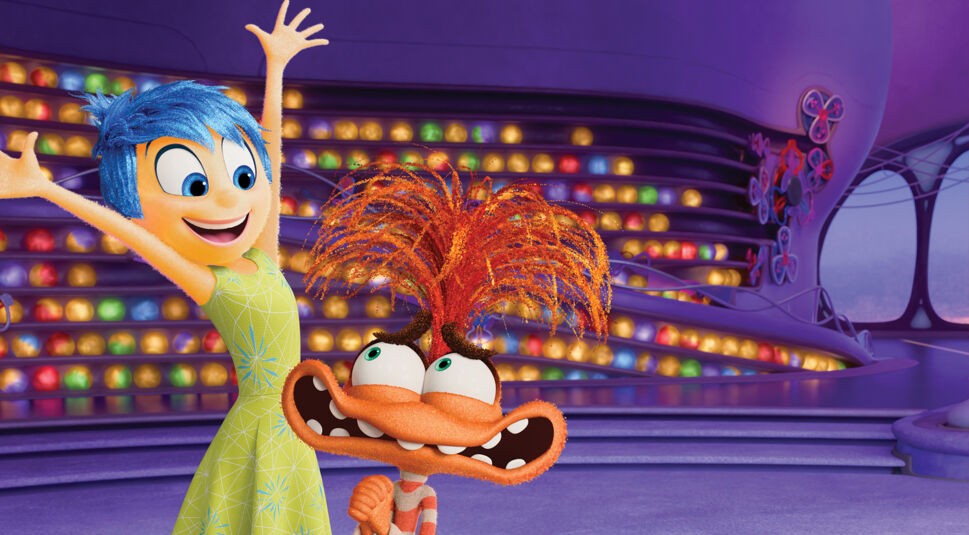 Auf dem Bild zu einem der besten Filme 2024, Alles steht Kopf 2, sind die Figuren Freude mit leuchtend blauem Haar und einem gelben Kleid sowie Wahnvorstellung mit orangefarbenem Fell und wild abstehenden Haaren zu sehen. Freude streckt begeistert die Arme hoch, während Wahnvorstellung mit großen Augen und einem breiten Grinsen posiert. Der Hintergrund zeigt eine futuristische, bunte Kulisse mit leuchtenden Kugeln.