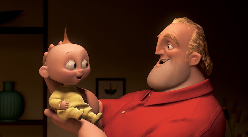 Auf dem Bild aus Die Unglaublichen hält Mr. Incredible, gekleidet in ein rotes Hemd, liebevoll Baby Jack-Jack in seinen Händen. Jack-Jack trägt einen gelben Strampler und lächelt begeistert, während die beiden sich ansehen. Die Szene wirkt warm und familiär, mit einem dunklen Hintergrund, der die Figuren hervorhebt.
