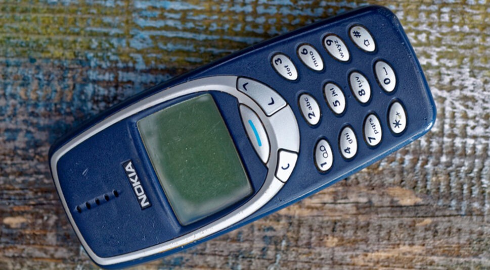 Ein Nokia-Handy, eines der bekanntesten Retro-Gadgets, liegt auf einer Holzoberfläche.