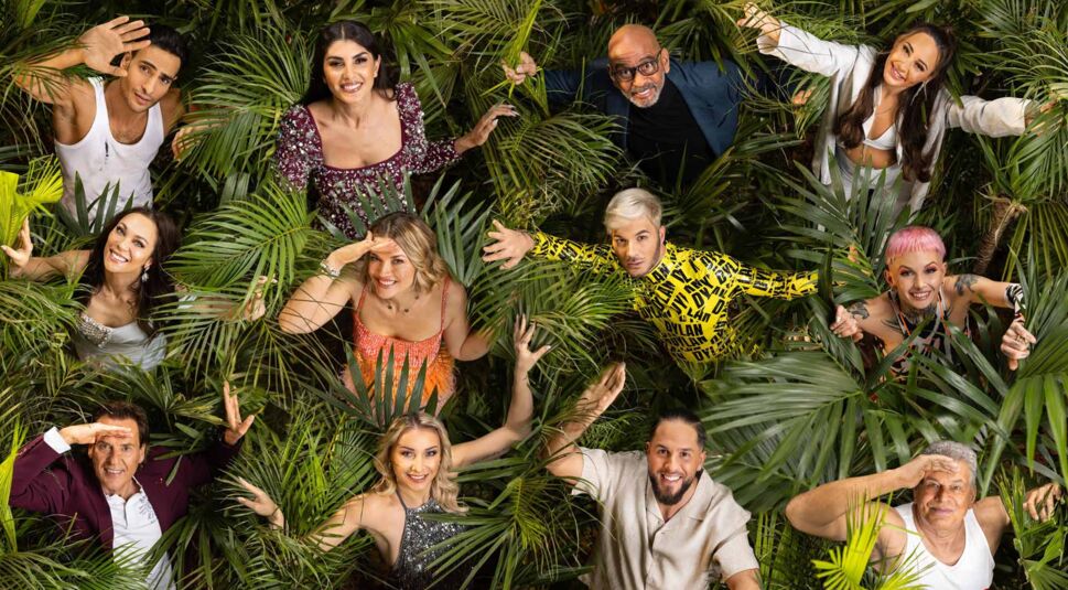 Auf dem Gruppenbild zum Dschungelcamp 2025 sind alle Kandidatinnen und Kandidaten zu sehen, umgeben von dichtem tropischem Blattwerk.