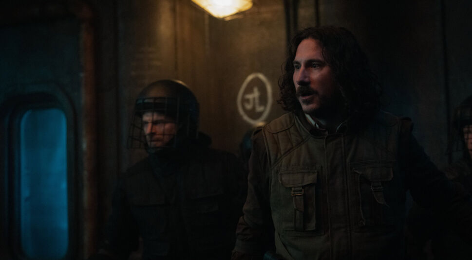 Im Silo Staffel 2 Ende erklärt-Artikel wird eine dramatische Szene während eines Aufstands im Silo gezeigt. Im Hintergrund ist ein Graffiti mit der Aufschrift „Juliette lebt“ zu sehen.