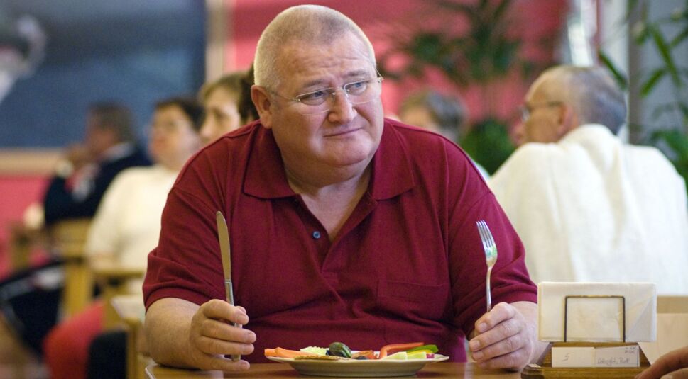 Horst Krause sitzt im Film "Krauses Kur" an einem Essenstisch.