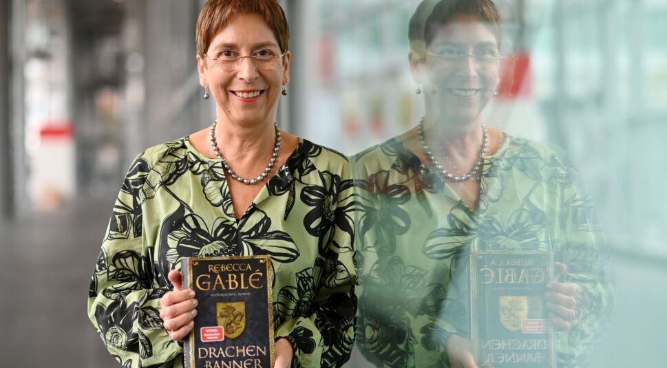Die Autorin Rebecca Gable hält ihr Buch "Drachenbanner" in den Händen