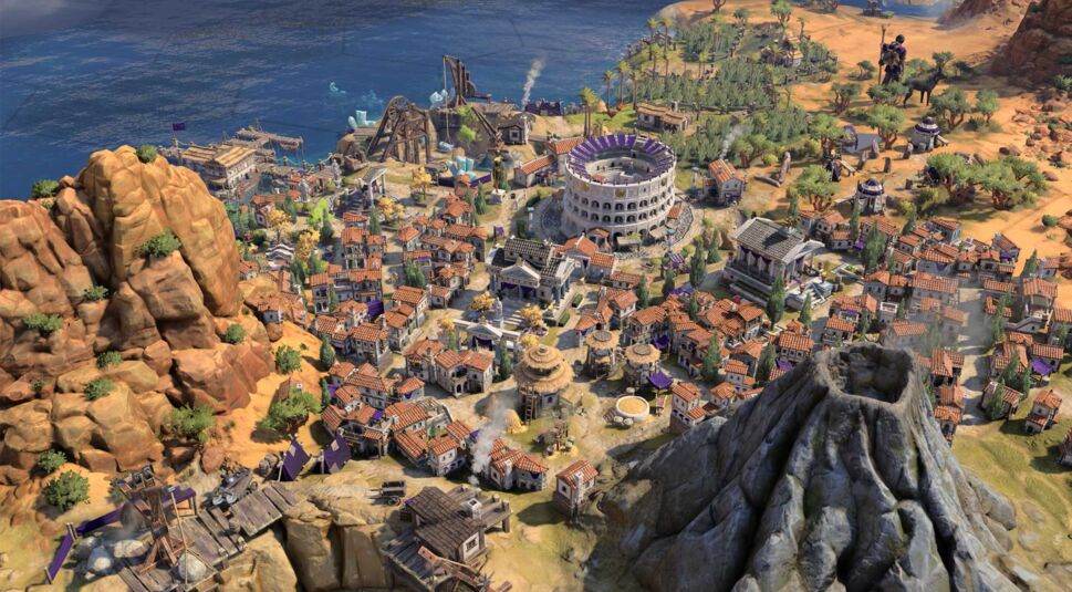 Das Bild zeigt eine eindrucksvolle Stadtansicht aus Civilization VII, die direkt an der Küste liegt. Im Zentrum der Stadt befindet sich ein großes Kolosseum, umgeben von dicht bebauten Häusern mit roten Ziegeldächern. Links ragen steile Felsen empor, während im Vordergrund ein Vulkan mit leichtem Rauch zu sehen ist, der potenzielle Gefahren birgt. Im Hintergrund erstreckt sich das Meer, und verschiedene Gebäude sowie Einheiten deuten auf florierenden Handel und militärische Stärke hin. Die Szene bietet wertvolle Civilization VII Tipps für den strategischen Städtebau in Küstenregionen.