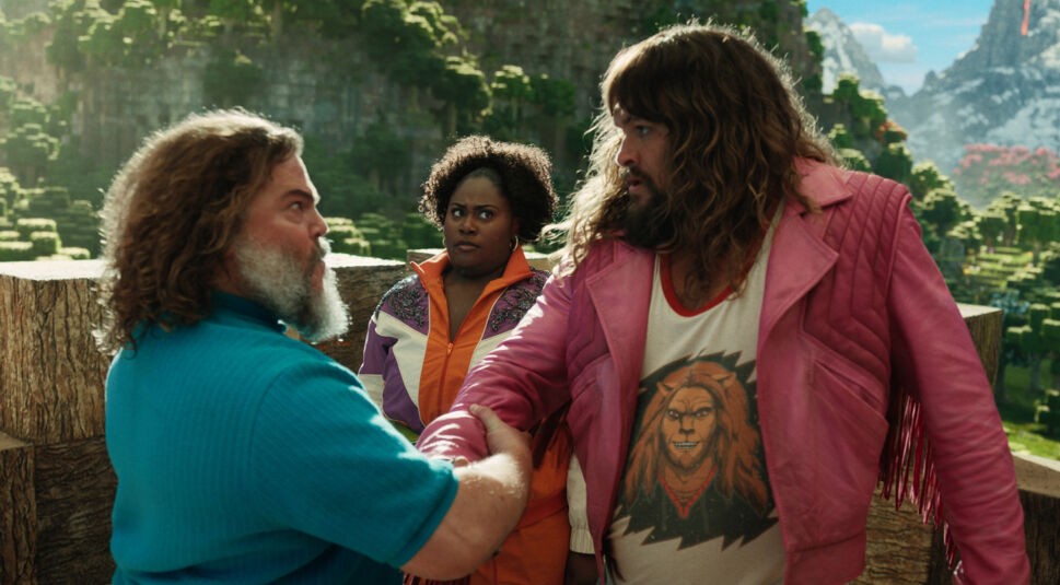 In dieser Szene aus Ein Minecraft Film schütteln Jack Black als Steve und Jason Momoa als Garrett die Hände, während Danielle Brooks als Dawn besorgt im Hintergrund steht. 