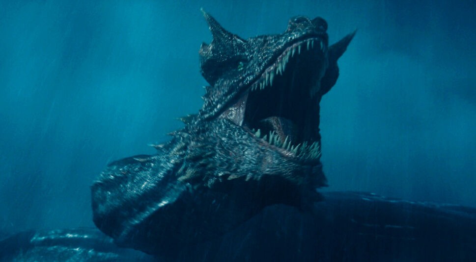 Auf diesem Bild, das aus House of the Dragon Staffel 2 stammt, ist ein gewaltiger Drache mit pechschwarzen Schuppen zu sehen, der bedrohlich sein Maul aufreißt und seine spitzen Zähne zeigt. Die düstere, sturmgepeitschte Atmosphäre unterstreicht die dramatische Wirkung der Szene – idealer Vorgeschmack für House of the Dragon Staffel 3.