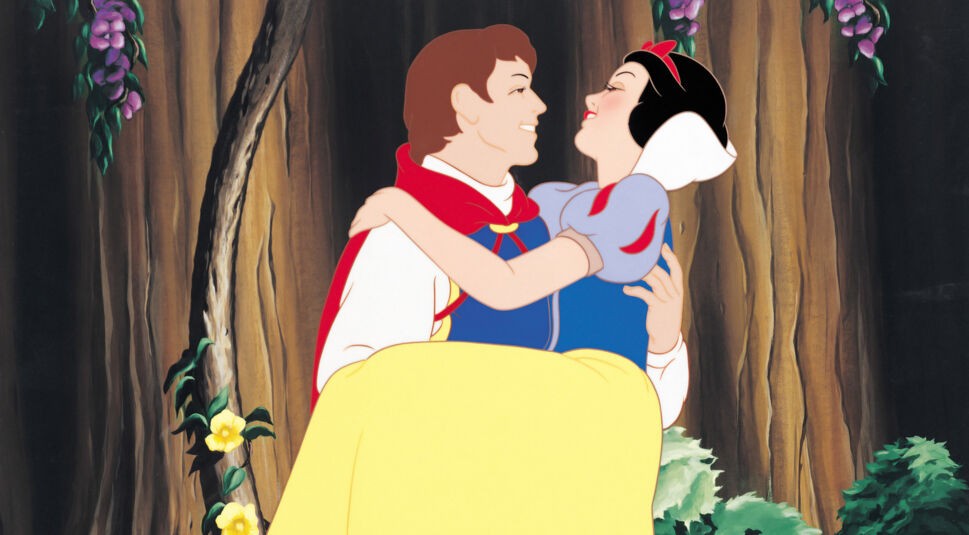 Auf dem Bild aus Schneewittchen und die sieben Zwerge (Disney, 1937) hält der Prinz Schneewittchen glücklich in seinen Armen. Beide lächeln sich verliebt an, während der Hintergrund eine märchenhafte Waldszene mit Blumen und Bäumen zeigt. Die handgezeichnete Animation verleiht der Szene einen nostalgischen Charme. Dieses Bild steht exemplarisch für den klassischen Stil des Originals im Vergleich zur Neuverfilmung Schneewittchen (2025).