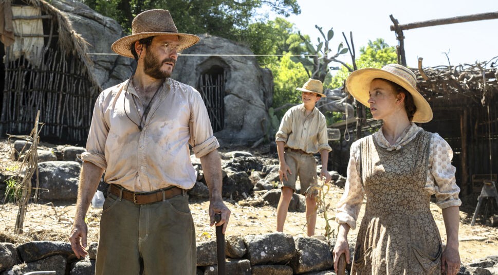 In einer Szene aus dem Film Eden, der von einer wahren Geschichte inspiriert ist, stehen Daniel Brühl als Heinz Wittmer, Sydney Sweeney als Margaret Wittmer und Jonathan Tittel als Sohn Harry Wittmer im Zentrum. Inmitten karger Natur wirken sie entschlossen und erschöpft zugleich. Die Stimmung unterstreicht die Herausforderungen, die das Leben in der Eden wahre Geschichte mit sich bringt.