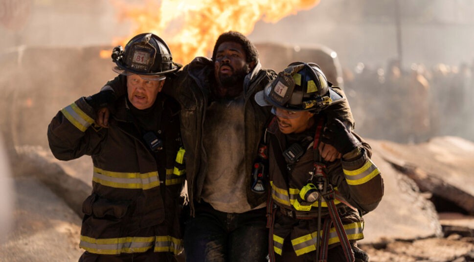 GigaTV-Highlights im April 2025: In einer dramatischen Szene aus der 13. Staffel von Chicago Fire retten zwei Feuerwehrmänner einen verletzten Mann aus einem brennenden Gebiet.