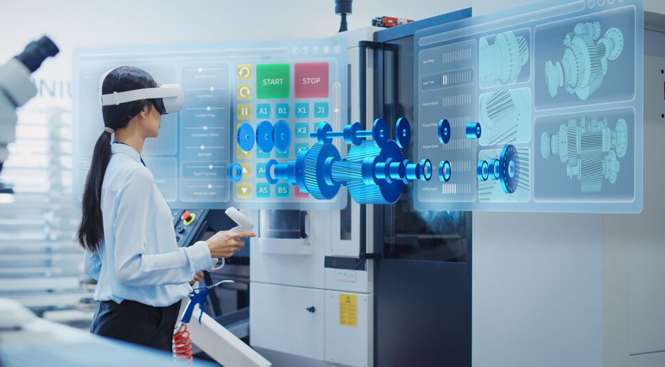 Auf dem symbolischen Bild zur Frage „Was ist Mixed Reality“ bedient eine Frau in einem industriellen Umfeld mit einer MR-Brille ein digitales Interface. Vor ihr schwebt ein holografisches 3D-Modell eines Getriebes mit technischen Details. Die Szene demonstriert anschaulich den Einsatz von Mixed Reality zur Visualisierung und Steuerung komplexer Industrieprozesse in Echtzeit.