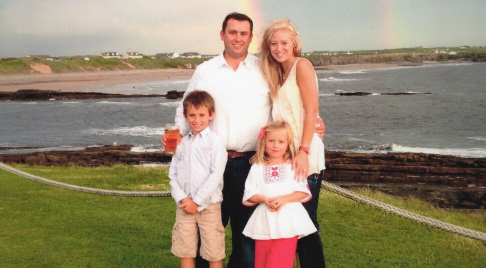 Tödlich: Eine Amerikanische Ehe - Jason Corbett mit seiner Ehefrau Molly und seinen beiden Kindern vor einer Küste mit Wasser.