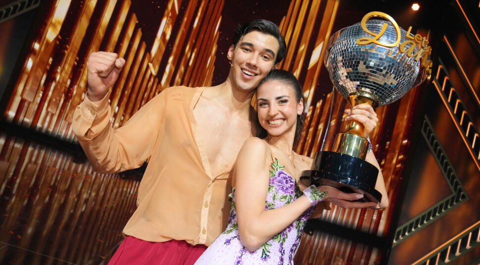 Die Sieger Diego Pooth und Ekaterina Leonova halten die Trophäe in der Hand und lachen zufrieden.