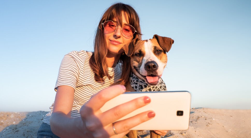 Eine Frau macht ein Selfie von sich und einem Hund.