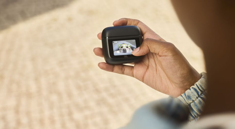 Hand hält das schwarze Ladecase der JBL Tour Pro 3 hoch.