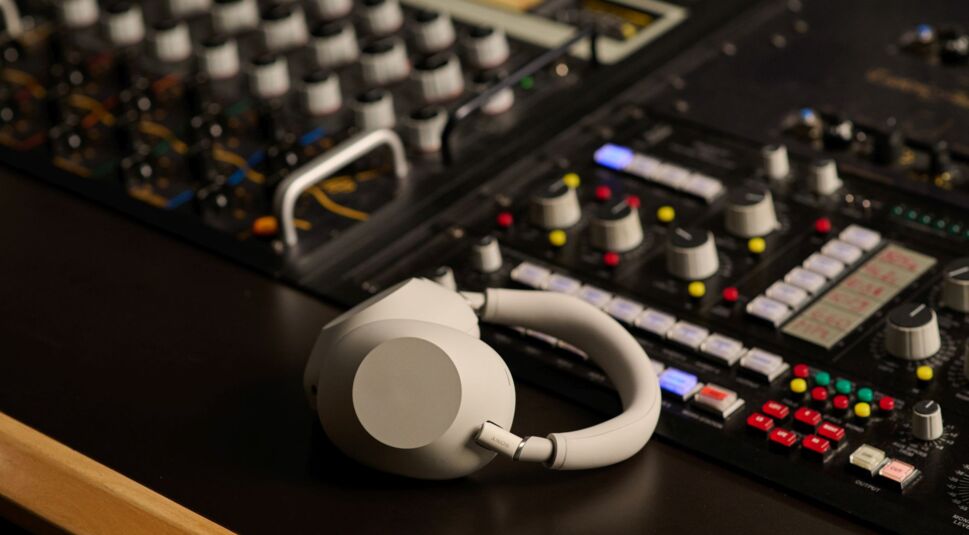 Die Sony WH-1000XM6 liegen auf einem Mischpult.