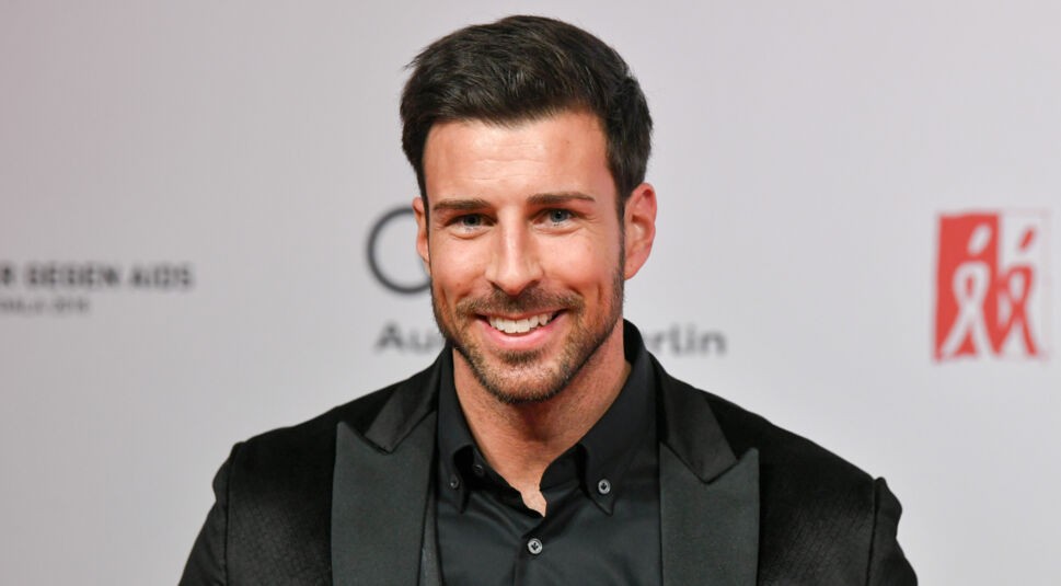 Auf dem Bild zur Übersicht Alle Bachelor ist Leonard Freier bei einer Charity-Veranstaltung zu sehen. Er trägt einen eleganten schwarzen Anzug mit dezentem Muster und ein schwarzes Hemd. Mit seinem breiten Lächeln und gepflegtem Auftreten verkörpert er den klassischen Gentleman unter den Bachelors – charmant, stilvoll und medienwirksam.