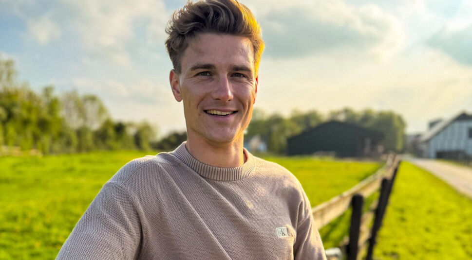 Bei Bauer sucht Frau 2025 steht Kandidat Friedrich in beigem Pullover lächelnd auf einem sonnenbeschienenen Hofweg mit grüner Wiese und Stallgebäuden im Hintergrund.