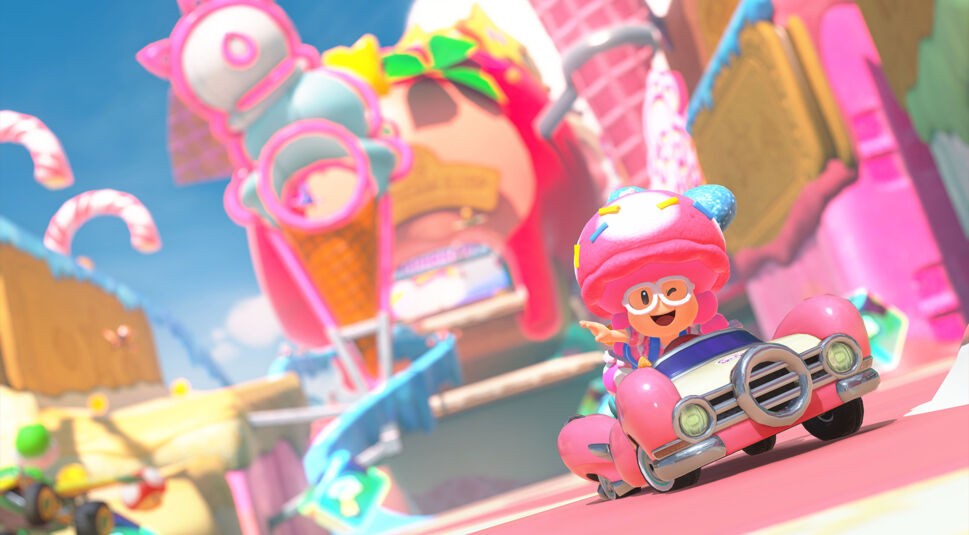 Auf dem Bild in dem Artikel zum Mario Kart World-Test fährt Toadette in einem rosa Retro-Kart durch eine bunte Welt.