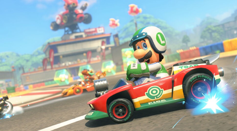 Im Bild zu Mario Kart World Tipps driftet Luigi in seinem roten Kart mit grün-weißer Rennkleidung dynamisch um eine Kurve. Im Hintergrund sind weitere Fahrer sowie eine bunte Rennkulisse mit Zuschauern und Figuren aus dem Mario-Universum zu sehen. Die Szene vermittelt Geschwindigkeit und Spannung im typischen Comic-Stil des Spiels.