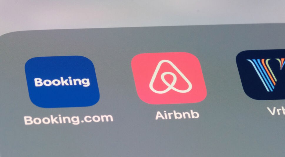 Auf dem Bild sind die Symbole der Reiseplanungs-Apps Booking.com und Airbnb nebeneinander auf einem Smartphone-Bildschirm zu sehen. Das blaue Icon von Booking.com steht links, daneben das rosafarbene Logo von Airbnb mit weißem Symbol in der Mitte. Die App-Icons wirken modern und stehen für digitale Reiseplanung.