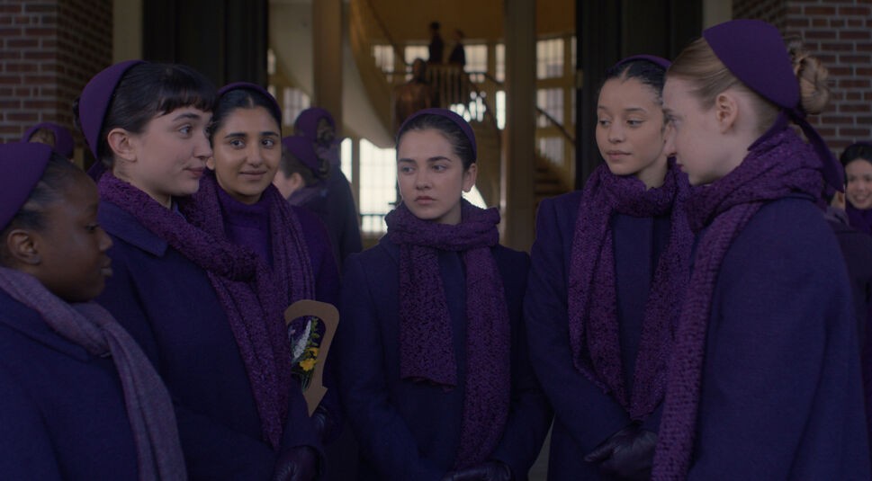 Auf dem Bild in dem Artikel zur neuen Serie „The Testaments“ stehen sechs junge Frauen in dunkellila Uniformen zusammen und unterhalten sich.