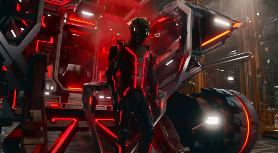 In dieser Szene aus Tron: Ares ist Ares zu sehen, die humanoid gestaltet ist und in einem schwarz-roten Design mit leuchtenden Linien auftritt.