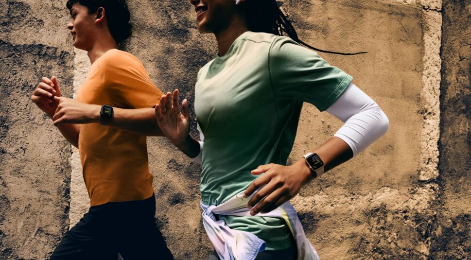 Zwei Läufer mit Apple Watch SE am Handgelenk laufen durch das Bild.