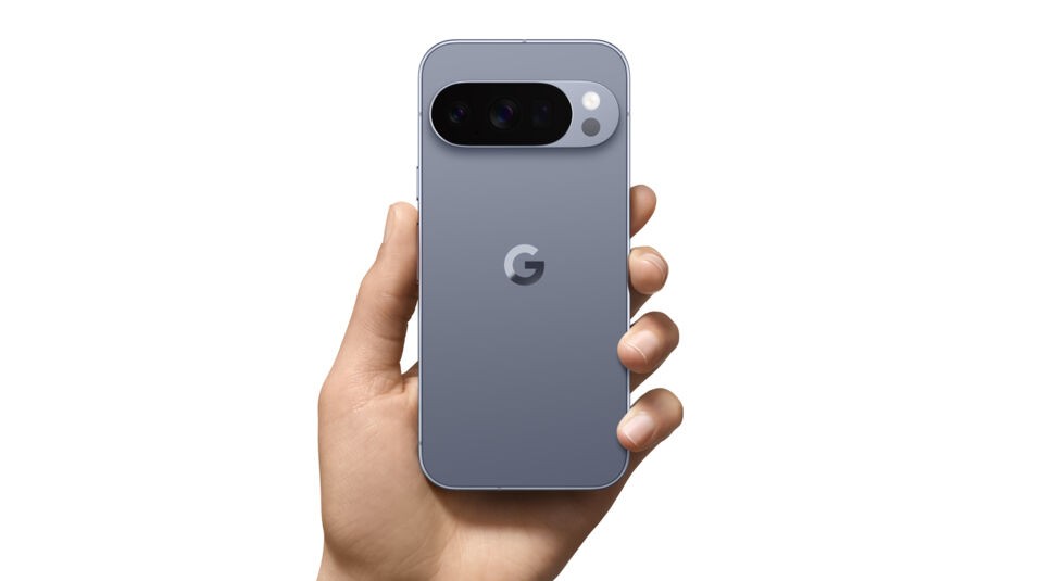 Das Bild zeigt das Google Pixel 10 Pro aus der Google Pixel 10-Reihe in der Farbe Moonstone (Grau), gehalten in einer Hand. Sichtbar ist die Rückseite mit dem charakteristischen Kameraelement mit drei Linsen und LED-Blitz. Das matte Gehäuse und das zentrale „G“-Logo betonen das moderne und schlichte Design des Smartphones.