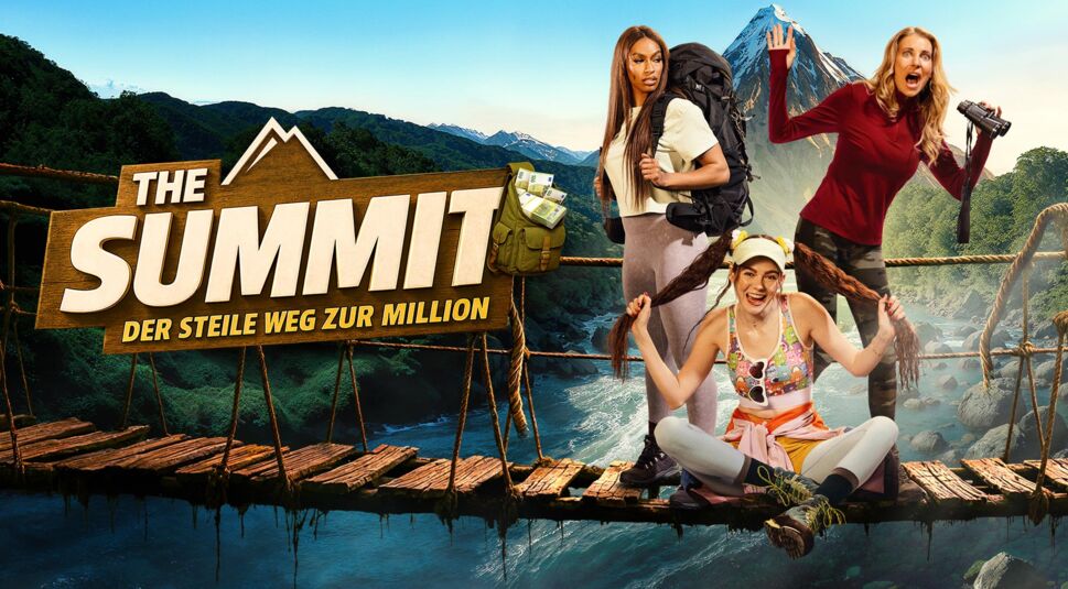 Auf dem Bild zur Sendung The Summit sind Cecilia Asoro, Klaudia Giez und Giulia Siegel als erste Gruppe der Show auf einer abenteuerlichen Hängebrücke in einer wilden Gebirgslandschaft zu sehen. Cecilia steht mit großem Wanderrucksack entschlossen da, Klaudia sitzt lachend auf dem Boden und hält ihre Zöpfe hoch, während Giulia mit Fernglas überrascht schaut. Im Hintergrund ragt ein schneebedeckter Gipfel auf.