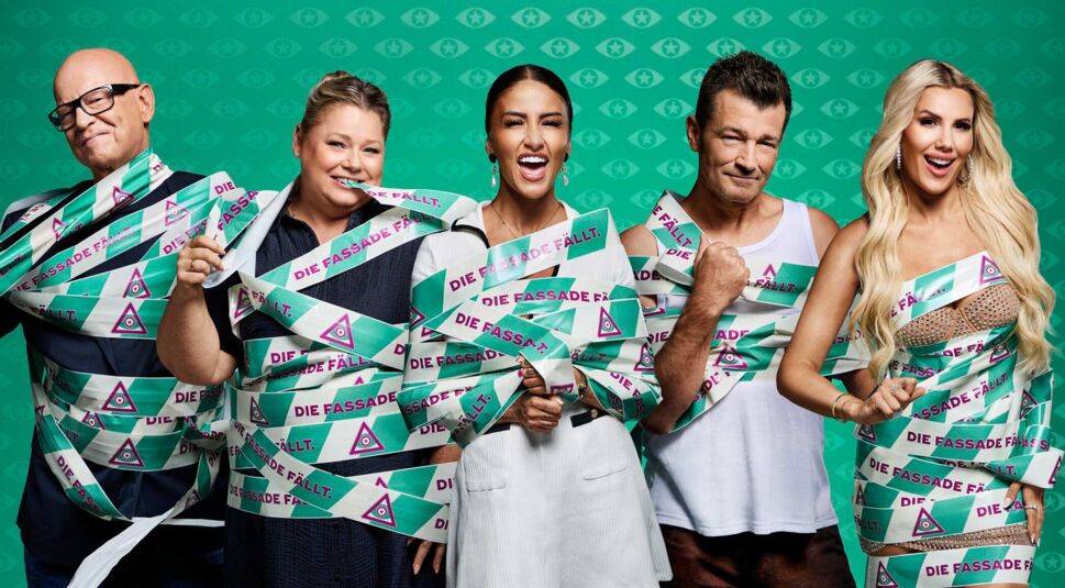 In den GigaTV-Highlights im Oktober 2025 ist ein Promobild zur Sendung „Promi Big Brother“ zu sehen. Fünf Kandidat:innen stehen nebeneinander vor einem türkisfarbenen Hintergrund mit Augen-Symbolen. Sie sind mit breiten, grün-weiß-lila-farbenen Bändern mit der Aufschrift „Die Fassade fällt“ umwickelt.