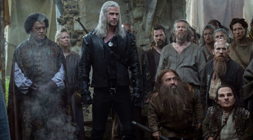 Liam Hemsworth als Geralt von Riva, umringt von weiteren Charakteren.