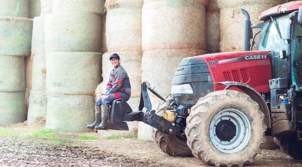 Auf dem Bild zu den internationalen Sendern und TV-Paketen bei Vodafone ist ein Landwirt aus der französischen Show „L’Amour est dans le Pré“ zu sehen. Er sitzt lächelnd auf einem Traktor der Marke Case IH vor großen Heuballen.