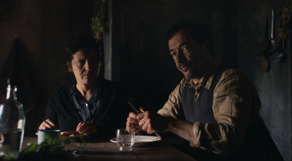 Auf dem Bild zu den internationalen Sendern und TV-Paketen bei Vodafone ist eine Szene aus der portugiesischen Serie „Finisterra“ zu sehen. Zwei Personen sitzen in einem spärlich beleuchteten Raum an einem Holztisch, umgeben von einfachen Gegenständen.