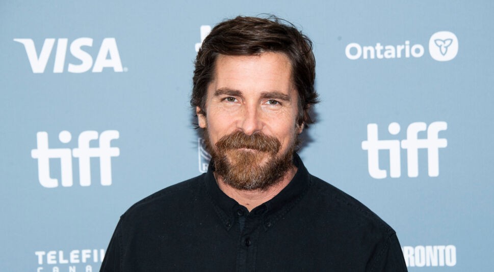Christian Bale ist auf diesem Symbolbild bei einer Filmpremiere zu sehen. Er trägt ein schwarzes Hemd und blickt mit leichtem Lächeln in die Kamera. Der Schauspieler ist Teil des Casts von The Bride 2026 und spielt dort eine zentrale Rolle im düsteren Sci-Fi-Drama.
