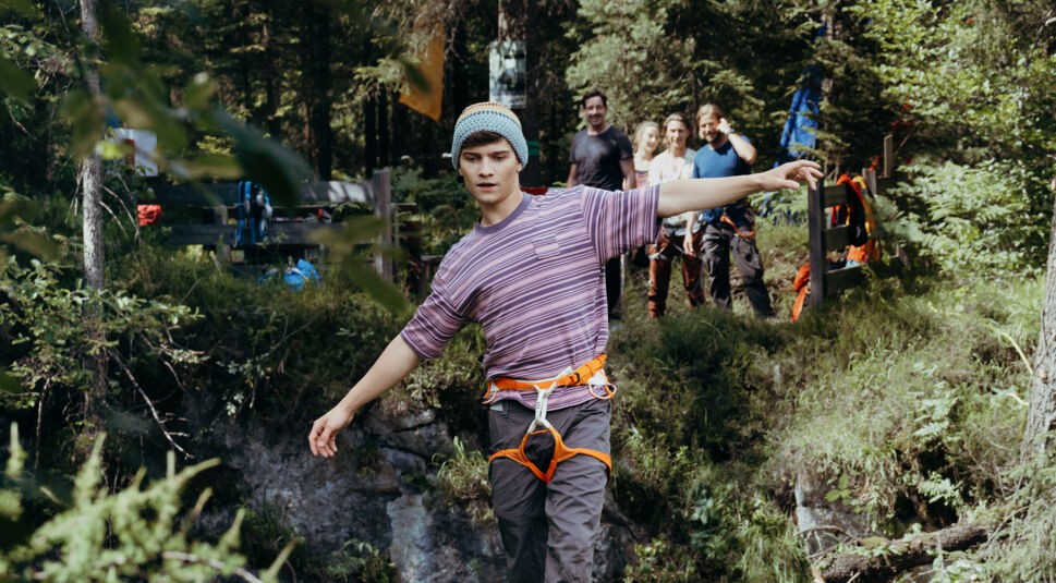 Jonas Meier (Juls Serger) balanciert mit ausgestreckten Armen über eine Slackline, die über den Abgrund gespannt ist.