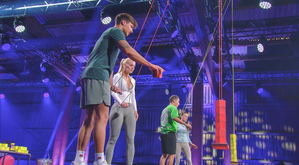 Auf dem Bild in dem Artikel zu den „Sommerhaus der Stars“-Gewinner:innen stehen Edda und Micha gemeinsam mit anderen Kandidat:innen in einer Spielarena.