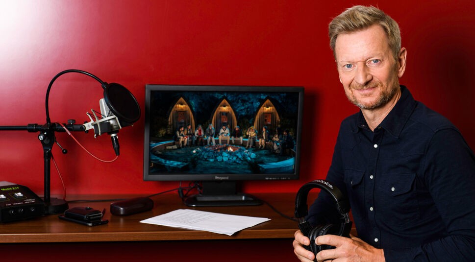 Auf dem Bild in dem Artikel zu „Werwölfe“ Staffel 2 ist Erzähler Michael Kessler vor einem roten Hintergrund in einem Tonstudio zu sehen.